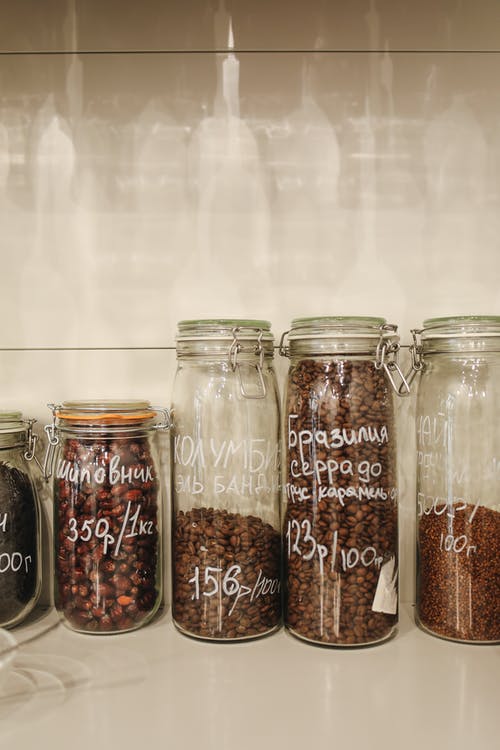 透明玻璃罐中的棕色和黑豆 · 免费素材图片