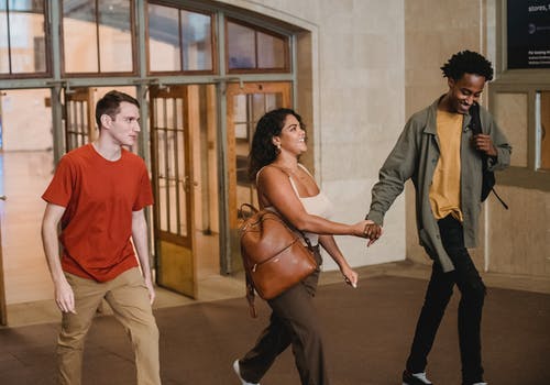 穿着红色衬衫和黑裤子的女人抱着穿着黑裤子的女人 · 免费素材图片