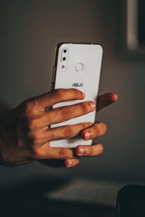 持有白色iphone 5 C的人 · 免费素材图片