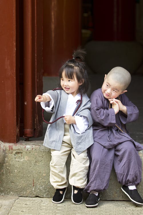 男孩和女孩坐在门口 · 免费素材图片