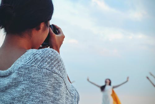 女人在白色的天空下跳舞的女人拍照 · 免费素材图片