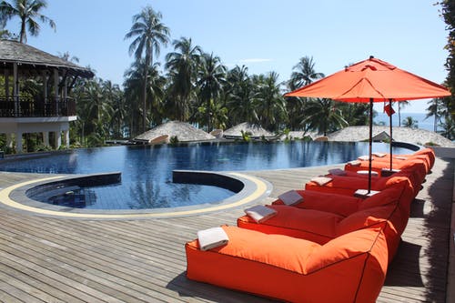 游泳池附近的橙色休息室 · 免费素材图片