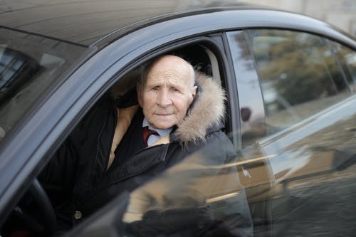 坐在车里的黑夹克的男人 · 免费素材图片