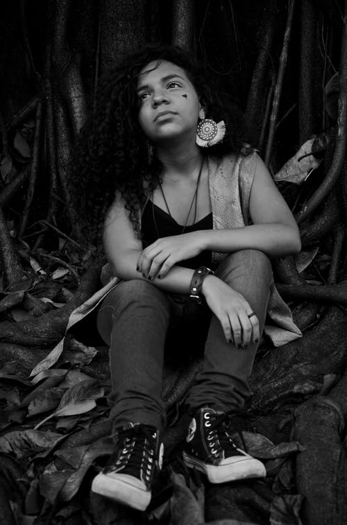 女人独自一人坐在树的根上的照片 · 免费素材图片