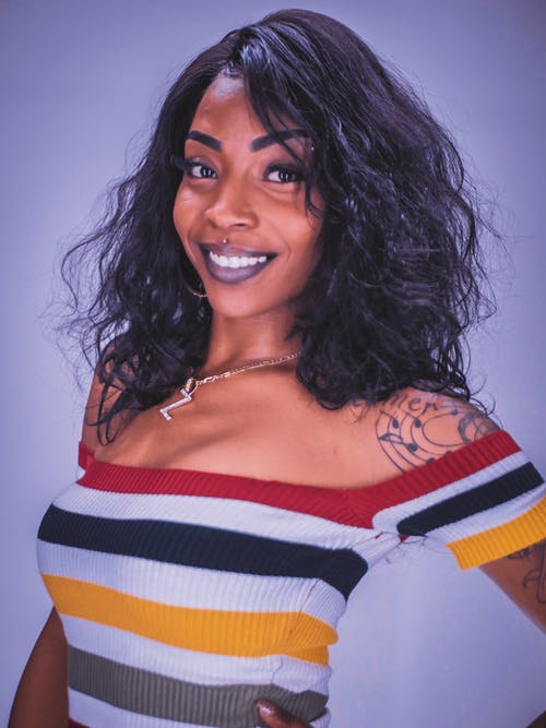 女人穿着多彩多姿的条纹露肩上衣 · 免费素材图片