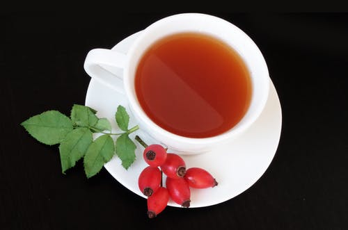 白色茶杯与旁边的红色水果 · 免费素材图片