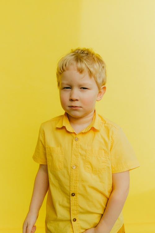 黄色的衬衫，站在墙附近的男孩 · 免费素材图片
