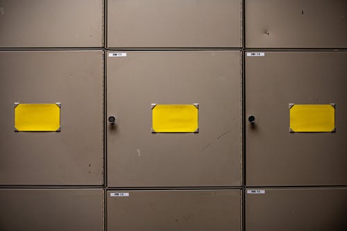 黄纸放在灰色的金属柜子上 · 免费素材图片