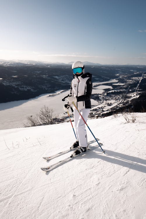 白夹克和白裤子的人在白雪皑皑的山上骑滑雪刀片 · 免费素材图片