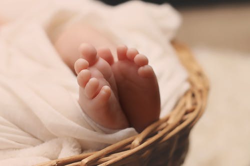 棕色柳条篮上的婴儿的脚 · 免费素材图片