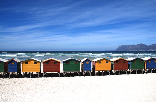白天在蓝天下海附近的多彩小屋 · 免费素材图片