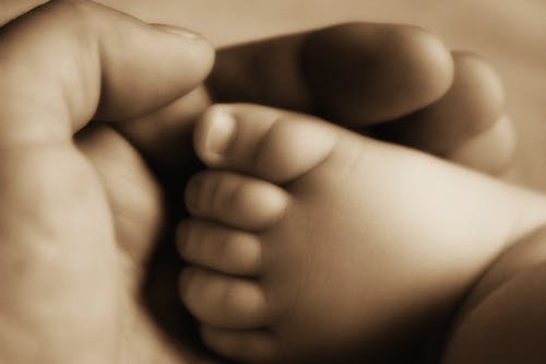 抱着婴儿脚的人 · 免费素材图片