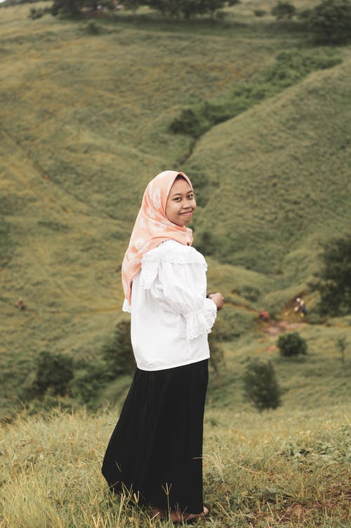 白色长袖衬衫和黑色的裙子，站在草地上的女人 · 免费素材图片