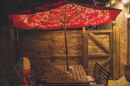 红色露台桌子上的灯串摄影 · 免费素材图片