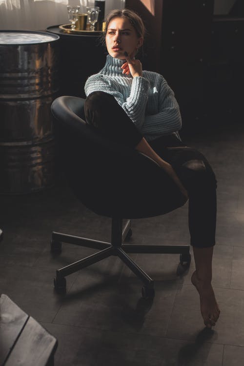 蓝色运动衫和黑色的裤子，坐在黑色的皮椅上的女人 · 免费素材图片