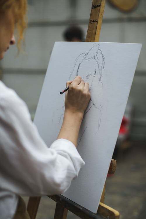 白色长袖衬衫在纸上画画的女人 · 免费素材图片