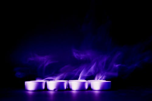 四个小圆蜡烛与紫色背景 · 免费素材图片