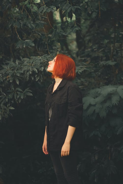 黑色按钮衬衫站在绿色的植物附近的女人 · 免费素材图片