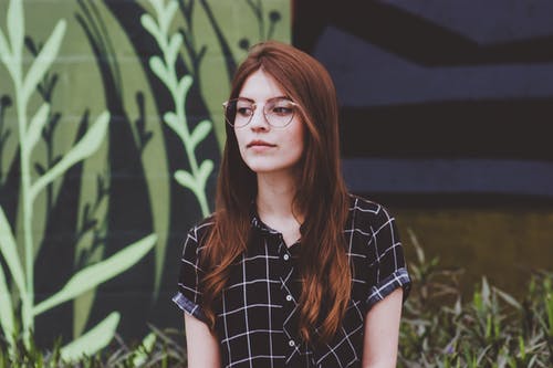 女人站在反对叶子植物 · 免费素材图片