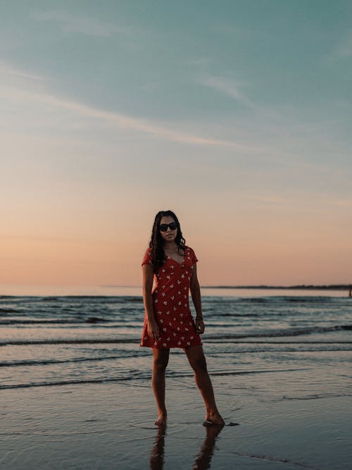 站在海滩上的红裙子的女人 · 免费素材图片