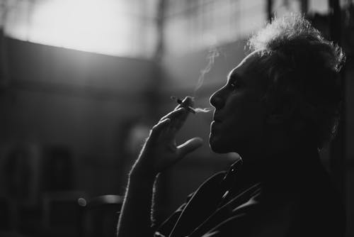 男子吸烟香烟的灰度照片 · 免费素材图片