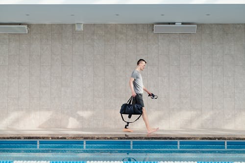 假腿在游泳池边散步的人 · 免费素材图片