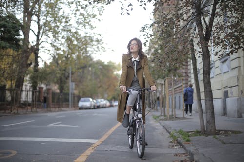 棕色外套骑自行车的女人 · 免费素材图片