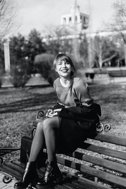 女人坐在板凳上的灰度摄影 · 免费素材图片
