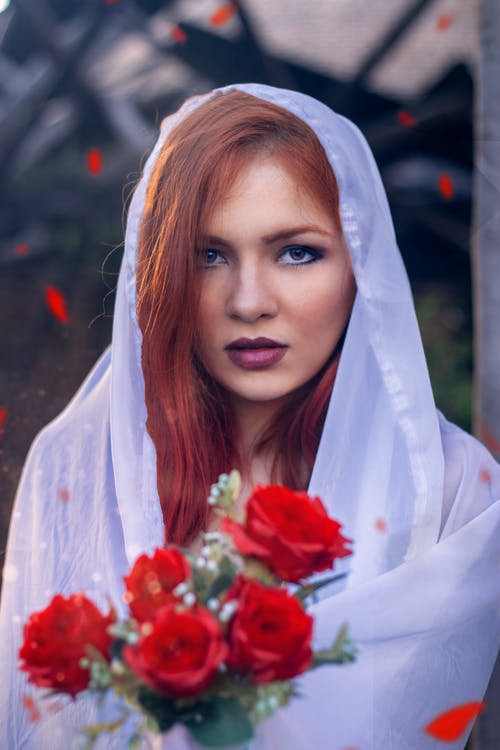 拿着红色玫瑰花束的白色头巾的女人 · 免费素材图片