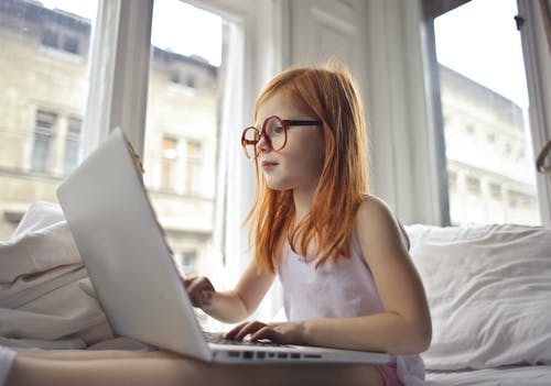一个女孩在电脑笔记本上看电影 · 免费素材图片