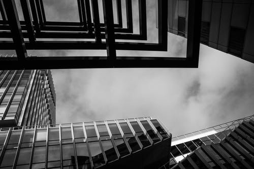 多云的天空下建筑物的灰度照片 · 免费素材图片