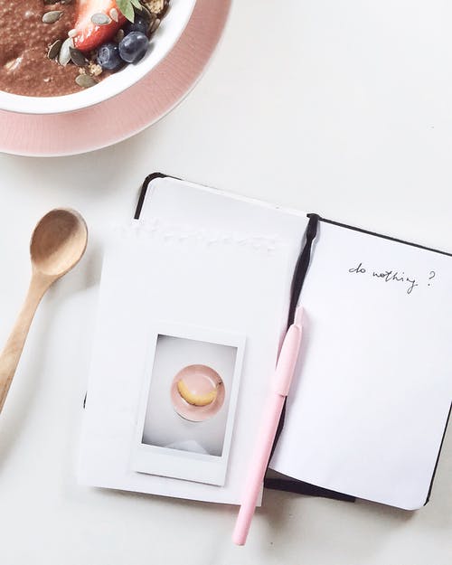 白书和黑书上的粉红色钢笔 · 免费素材图片