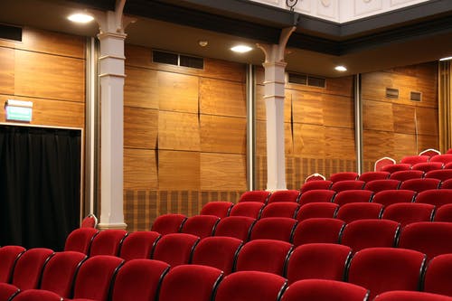 红色剧院椅附近白色混凝土支柱 · 免费素材图片