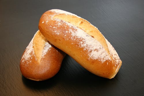 黑色表面上的两个烤的面包 · 免费素材图片