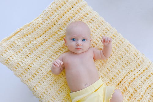 婴儿躺在黄色纺织的黄色短裤 · 免费素材图片