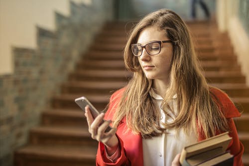 女人控股银智能手机 · 免费素材图片