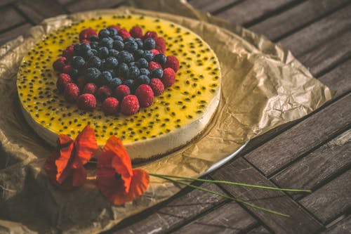 棕色木制表面上的红色和蓝莓蛋糕 · 免费素材图片