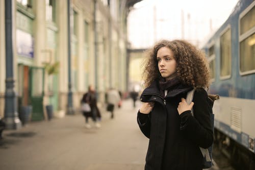 黑色外套站在地铁旁边的女人 · 免费素材图片