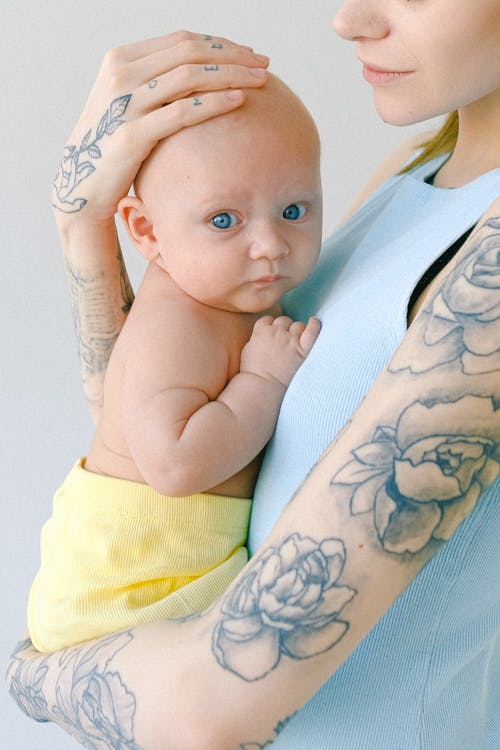 女人抱着一个婴儿 · 免费素材图片