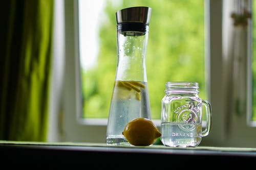 玻璃梅森罐和玻璃蒸馏瓶附近的黄色柠檬浅焦点摄影 · 免费素材图片