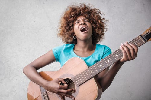 唱歌时弹吉他的女人 · 免费素材图片