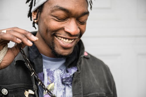 男人穿着灰色牛仔夹克和蓝色船员的脖子t恤微笑 · 免费素材图片