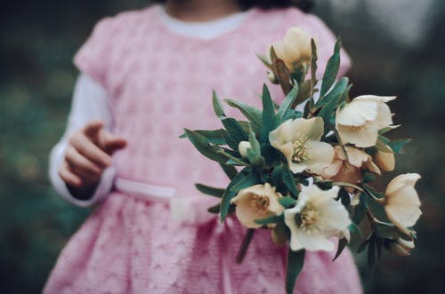 女孩拿着花的选择聚焦照片 · 免费素材图片