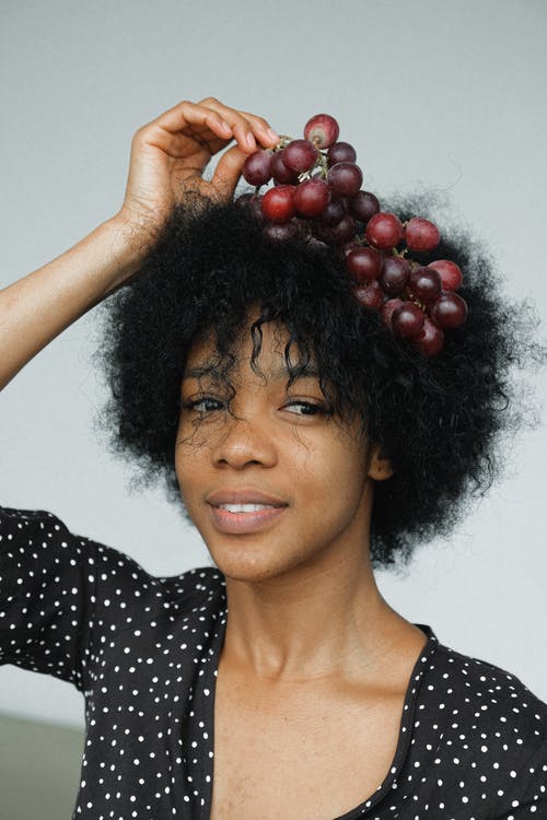 黑色和白色的圆点衬衫，拿着红色的圆形水果的女人 · 免费素材图片