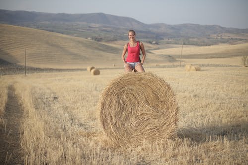粉红色的背心站在棕色草地上的女人 · 免费素材图片