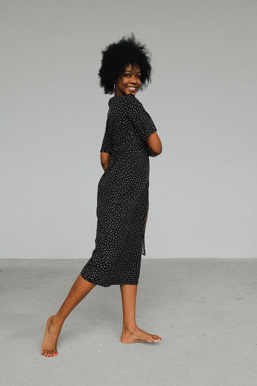 黑色和白色圆点裙站在地板上的女人 · 免费素材图片