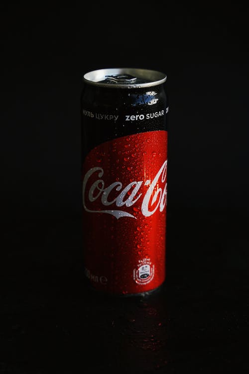 黑色表面上的可口可乐罐 · 免费素材图片