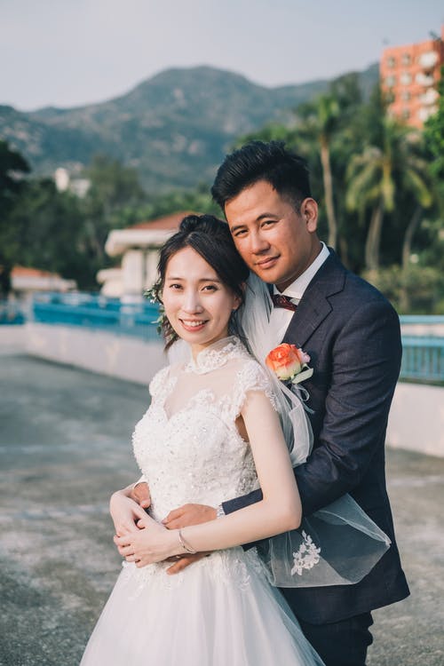 亚洲新婚夫妇在热带公园深情相拥 · 免费素材图片