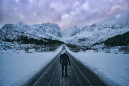 在积雪覆盖的路上行走的人 · 免费素材图片