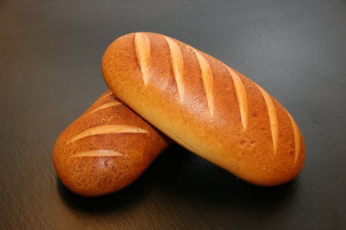 桌上的两个棕色烤的面包 · 免费素材图片